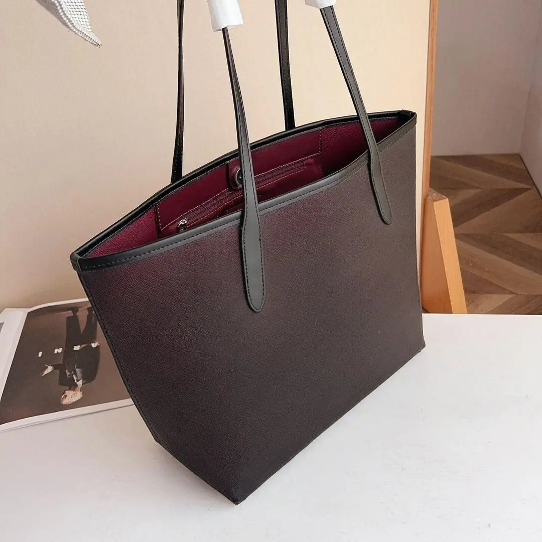 Black large tote bag with thin leather top handles, open-top design shoulder bag.